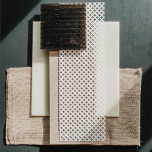 A dark green background with layered material samples of glass, tile, burlap and wood